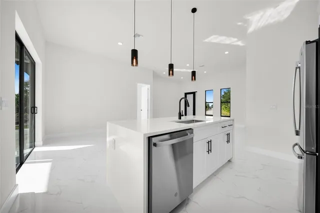 a kitchen with stainless steel appliances a refrigerator and a sink