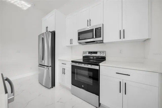 a kitchen with stainless steel appliances a refrigerator sink and microwave