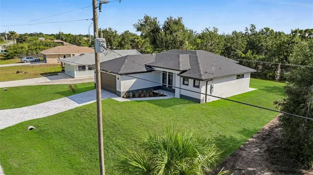 a aerial view of a house with a big yard potted plants and large tree