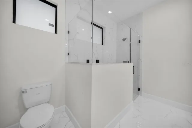 a bathroom with a toilet and a shower