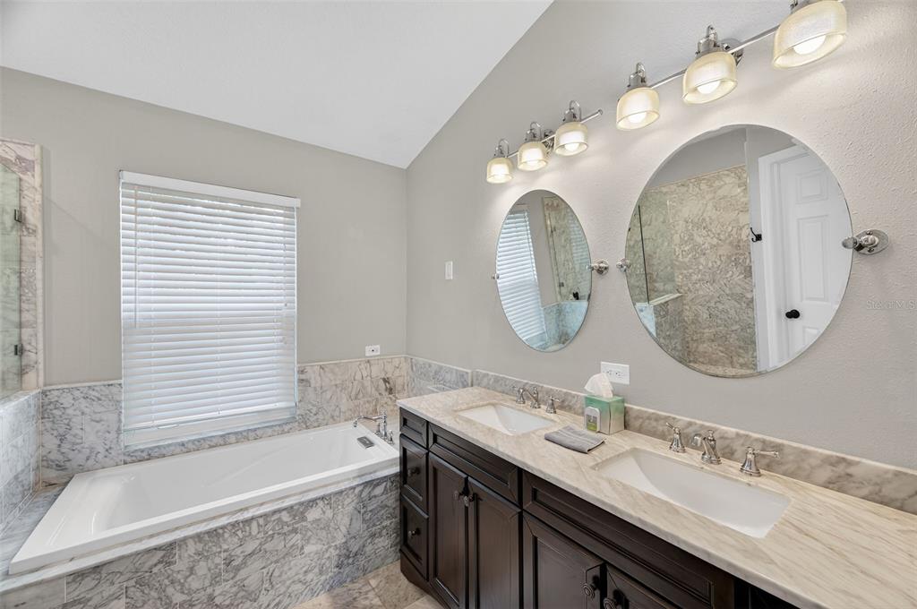 10539 Gooseberry Court Trinity, FL 34655 - Photo 18 of 52 a bathroom with a double vanity sink mirror and bathtub