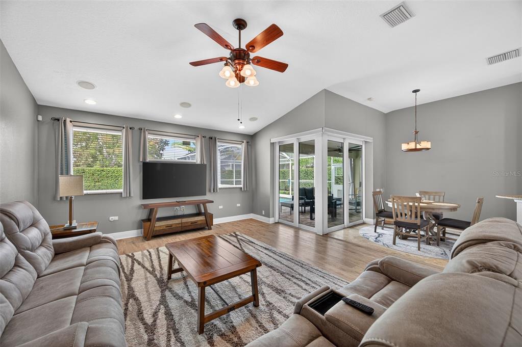 10539 Gooseberry Court Trinity, FL 34655 - Photo 2 of 52 a living room with furniture and a flat screen tv with wooden floor
