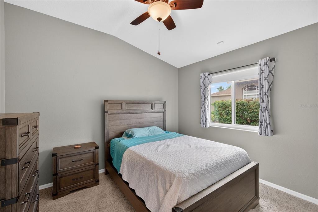 10539 Gooseberry Court Trinity, FL 34655 - Photo 21 of 52 a bedroom with a bed and a chandelier