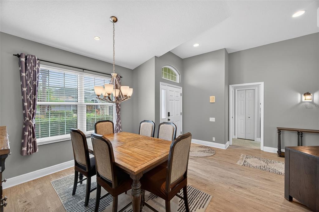 10539 Gooseberry Court Trinity, FL 34655 - Photo 6 of 52 a dining room with furniture a chandelier and wooden floor