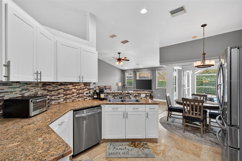 10539 Gooseberry Court Trinity, FL 34655 - Photo 10 of 52 a kitchen with a sink stove and chairs