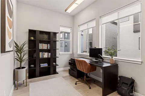 a view of a workspace with furniture and a window