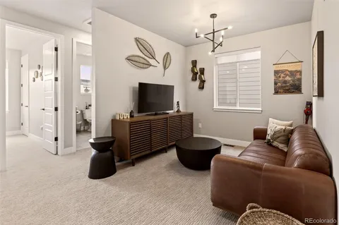 a living room with furniture a flat screen tv and a window