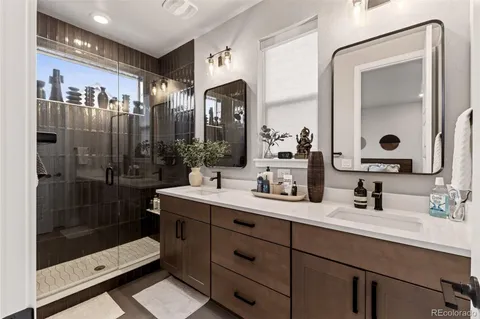 a bathroom with a double vanity sink mirror and shower