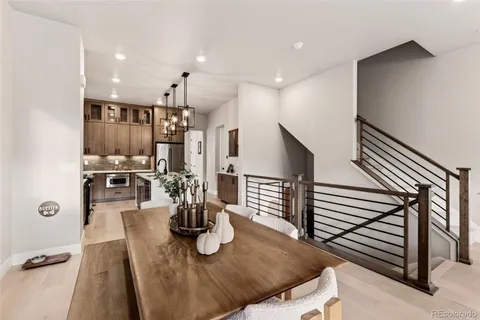 a kitchen with stainless steel appliances kitchen island granite countertop a refrigerator dining table and chairs