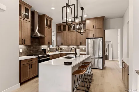 a kitchen with stainless steel appliances a sink a stove a refrigerator and cabinets