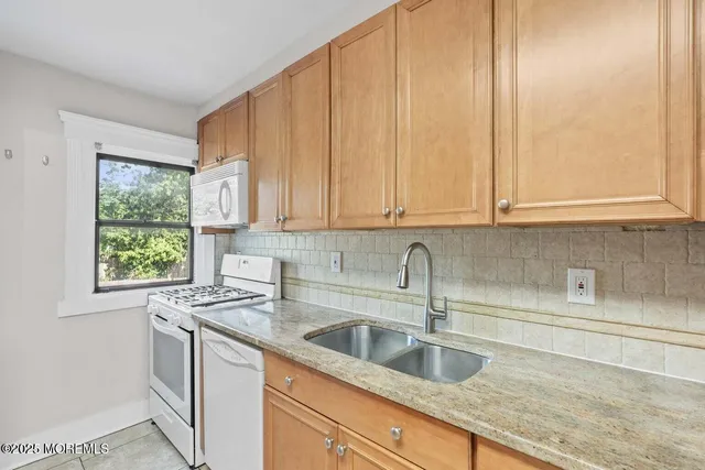 a kitchen with stainless steel appliances granite countertop white cabinets a sink and dishwasher