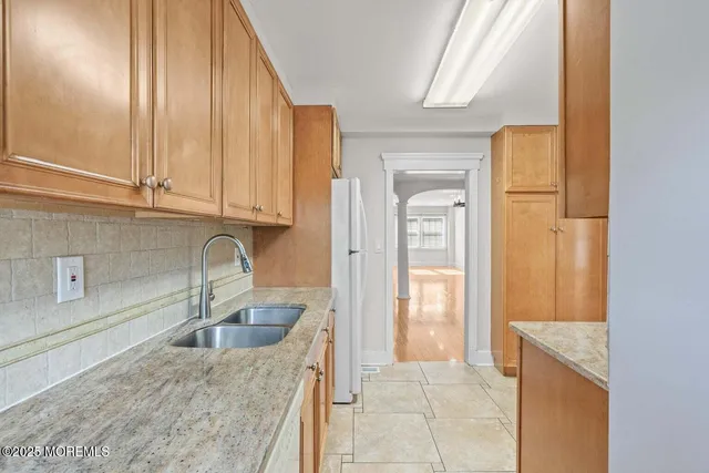 a kitchen with stainless steel appliances granite countertop a sink and a refrigerator