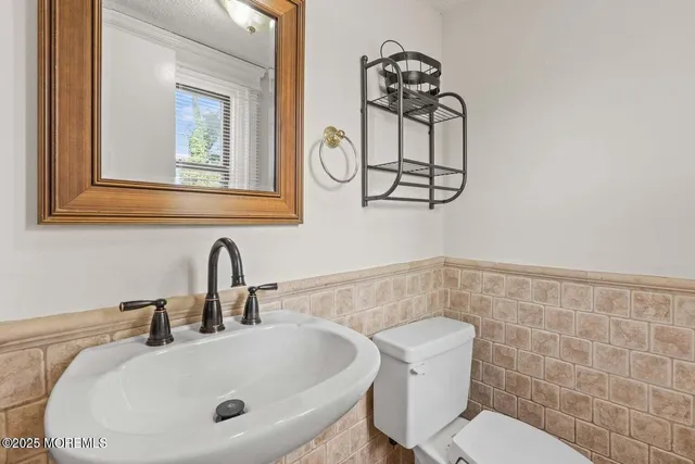 a bathroom with a sink a toilet and mirror