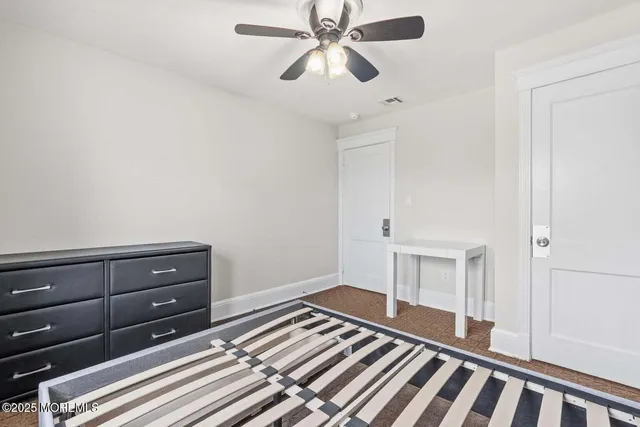 a bedroom with a bed and a chandelier fan