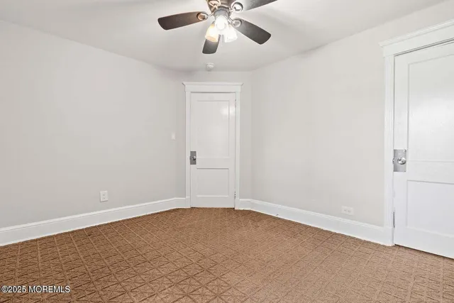 an empty room with chandelier fan
