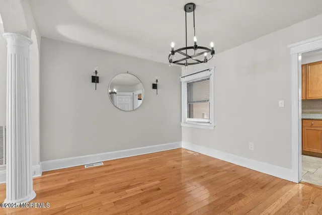 a view of a room with wooden floor chandelier and entryway