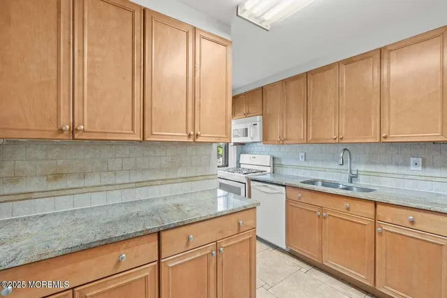 a kitchen with stainless steel appliances granite countertop a sink a stove and cabinets
