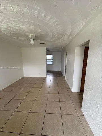 a view of a livingroom with an empty space and a window