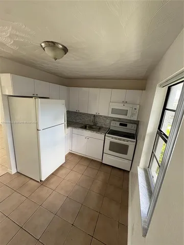 a kitchen with granite countertop a refrigerator and a stove