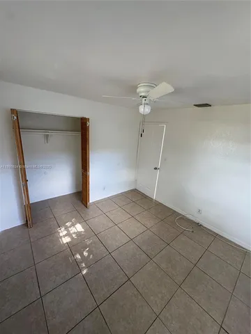 a view of a room with an empty space and a ceiling fan of window