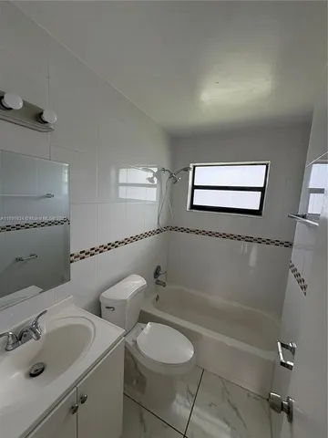 a bathroom with a sink mirror vanity and toilet