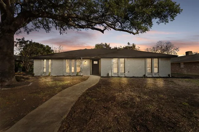 a big yard with table and chairs under an umbrella