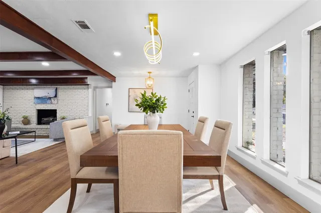 a dining room with furniture potted plants and wooden floor