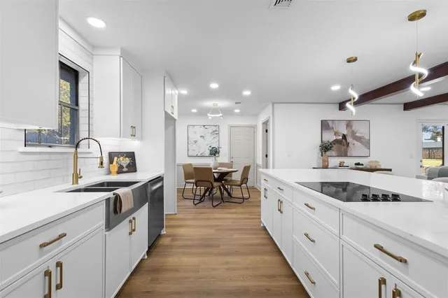 a large kitchen with stainless steel appliances granite countertop a lot of counter space and a sink