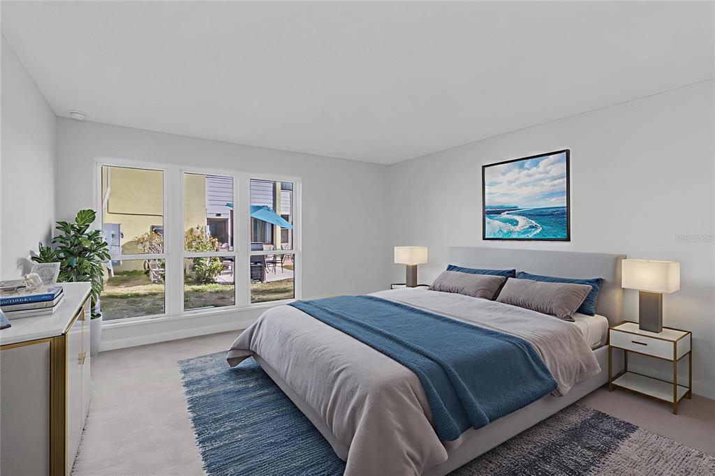 1 Windrush Boulevard, Unit 87 Indian Rocks Beach, FL 33785 - Photo 22 of 54 a bedroom with a large bed and a wooden floor