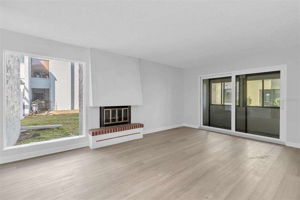 1 Windrush Boulevard, Unit 87 Indian Rocks Beach, FL 33785 - Photo 3 of 54 an empty room with floor to ceiling window and fireplace