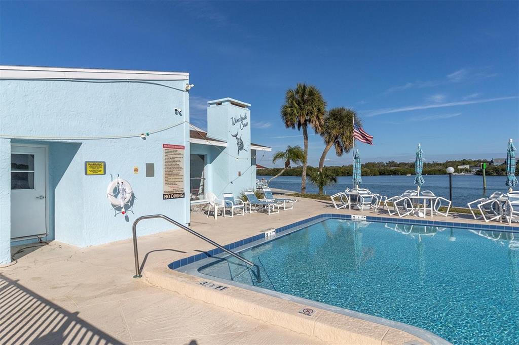 1 Windrush Boulevard, Unit 87 Indian Rocks Beach, FL 33785 - Photo 35 of 54 a view of a swimming pool with a table and chairs
