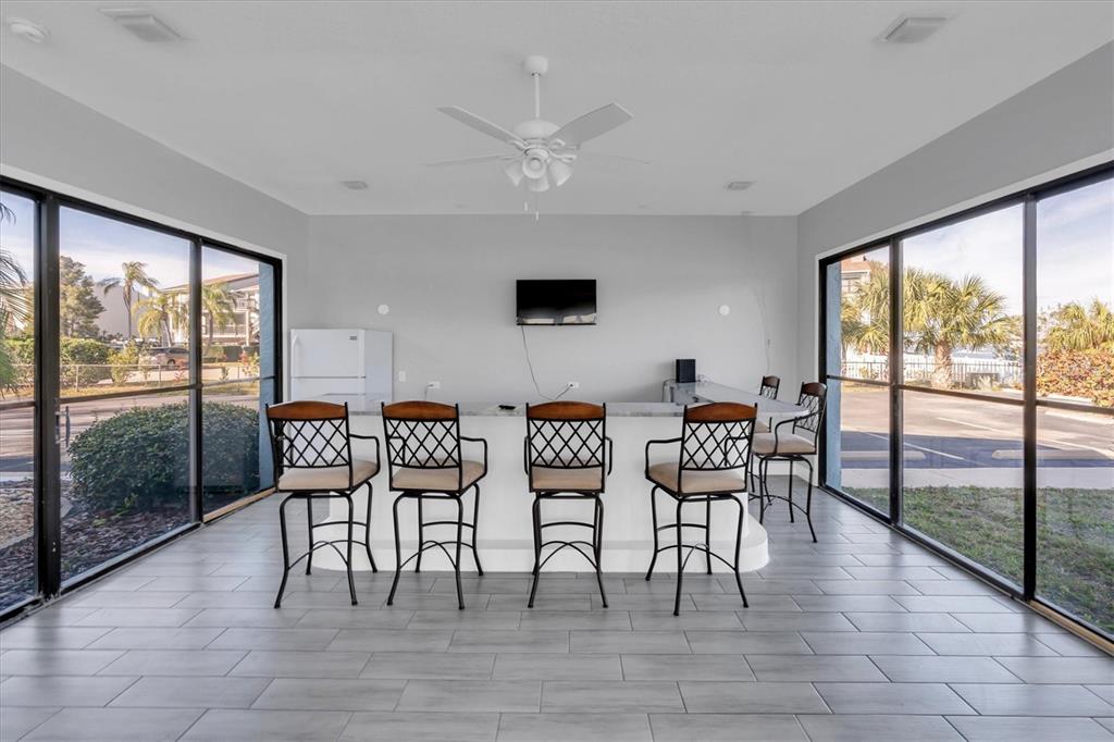 1 Windrush Boulevard, Unit 87 Indian Rocks Beach, FL 33785 - Photo 45 of 54 a view of a dining room with furniture and floor to ceiling windows