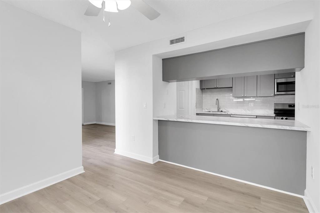 1 Windrush Boulevard, Unit 87 Indian Rocks Beach, FL 33785 - Photo 8 of 54 a kitchen with granite countertop a sink and cabinets