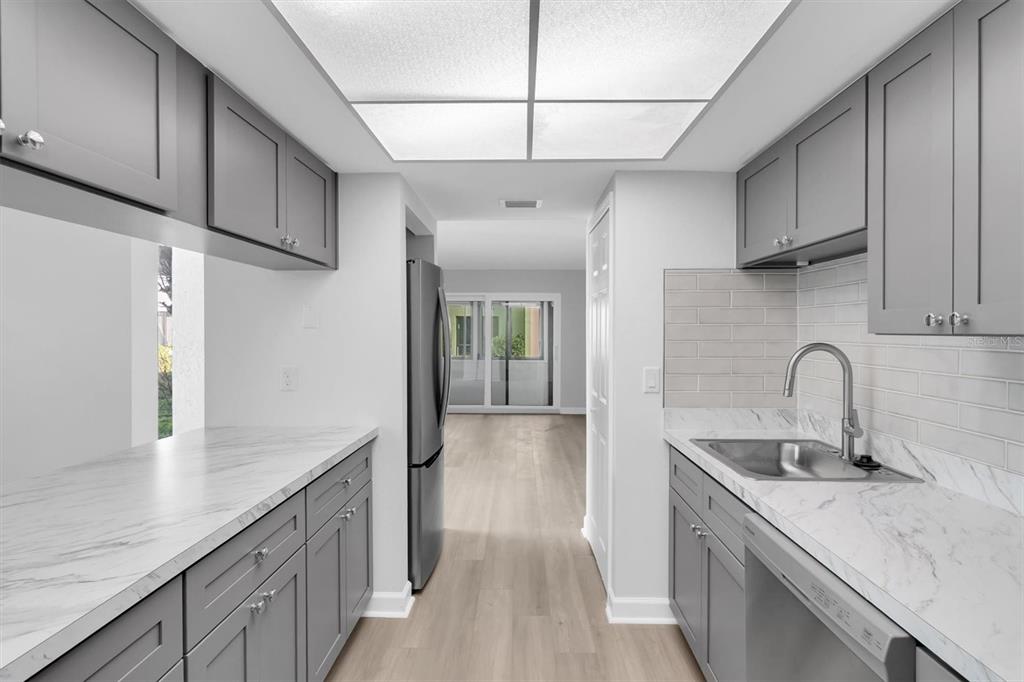 1 Windrush Boulevard, Unit 87 Indian Rocks Beach, FL 33785 - Photo 10 of 54 a kitchen with a sink cabinets and wooden floor