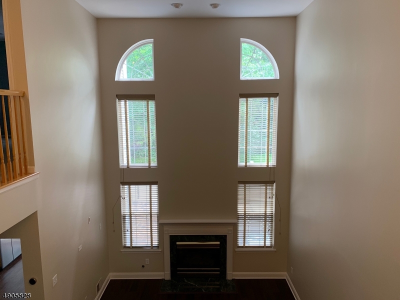 105 Well Sweep Road, Unit 105 Whitehouse Station, NJ 08889 - Photo 6 of 22 an entryway with wooden floor cabinet and mirror
