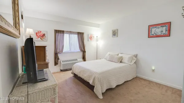 a bedroom with a bed next to a window