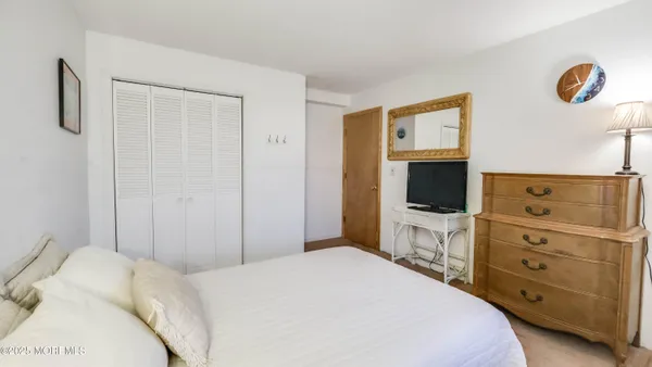 a bedroom with a bed and a flat tv screen tv