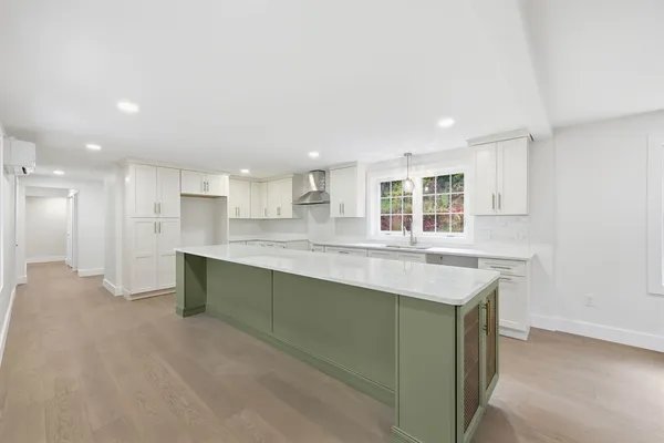 a large kitchen with kitchen island a sink stainless steel appliances and cabinets