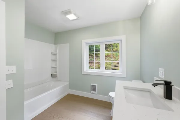 a bathroom with a tub sink and a window