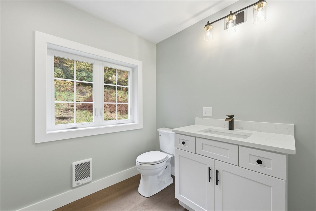 75 Lead Mine Road Southampton, MA 01073 - Photo 22 of 42 a bathroom with a toilet a sink a mirror and a window
