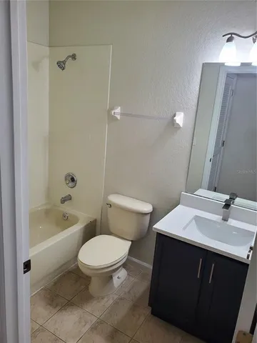 a bathroom with a sink a toilet a mirror a bathtub and shower