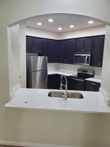a kitchen with kitchen island a counter top space cabinets and stainless steel appliances