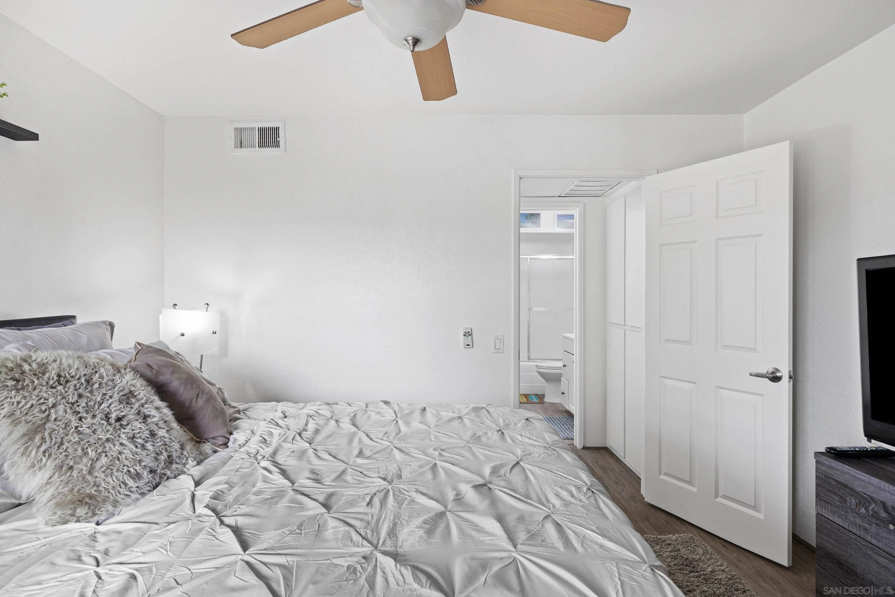 6406 Friars Road, Unit 338 San Diego, CA 92108 - Photo 21 of 36 a bedroom with a bed and wooden floor