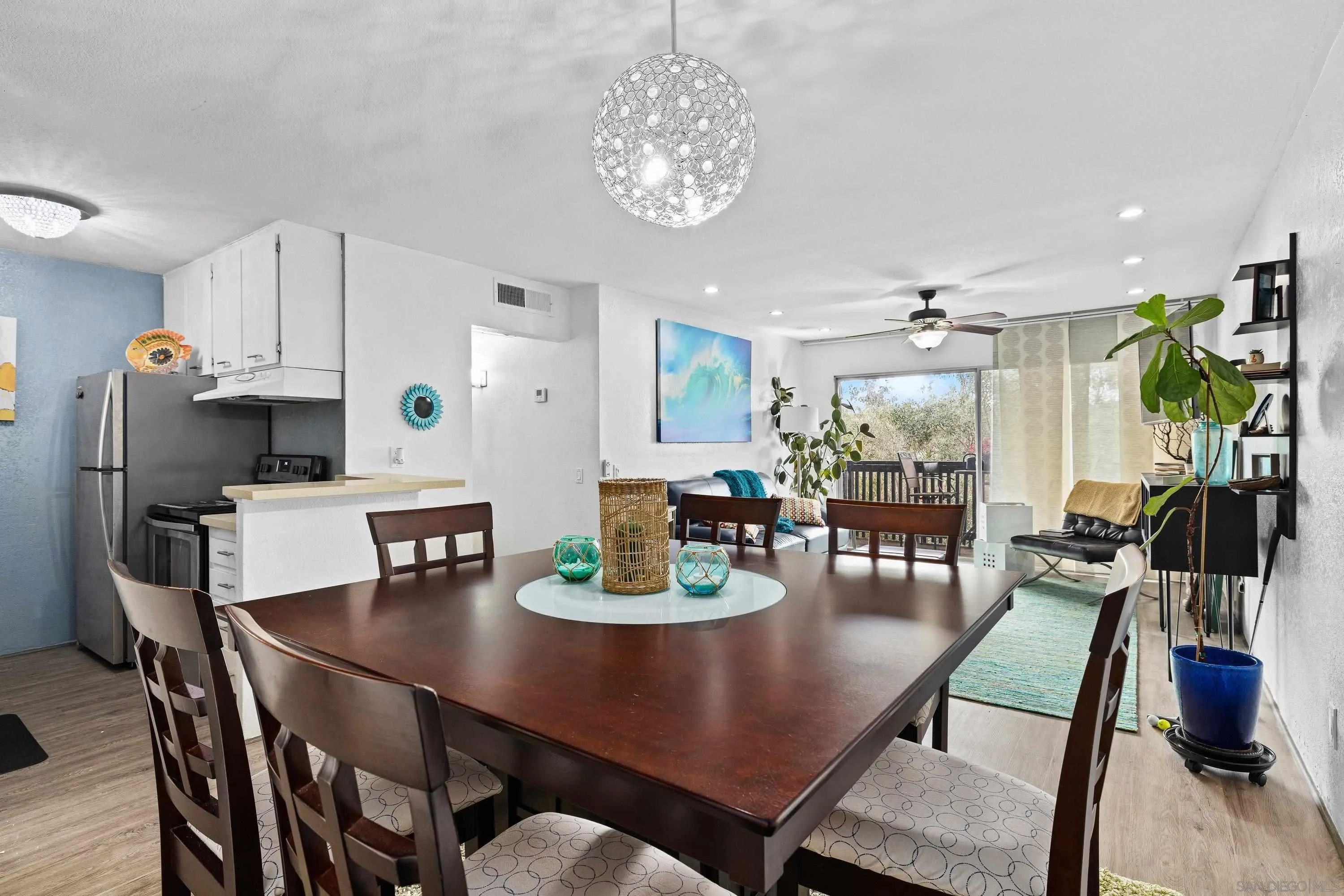 6406 Friars Road, Unit 338 San Diego, CA 92108 - Photo 3 of 36 a view of a dining room with furniture a chandelier and wooden floor