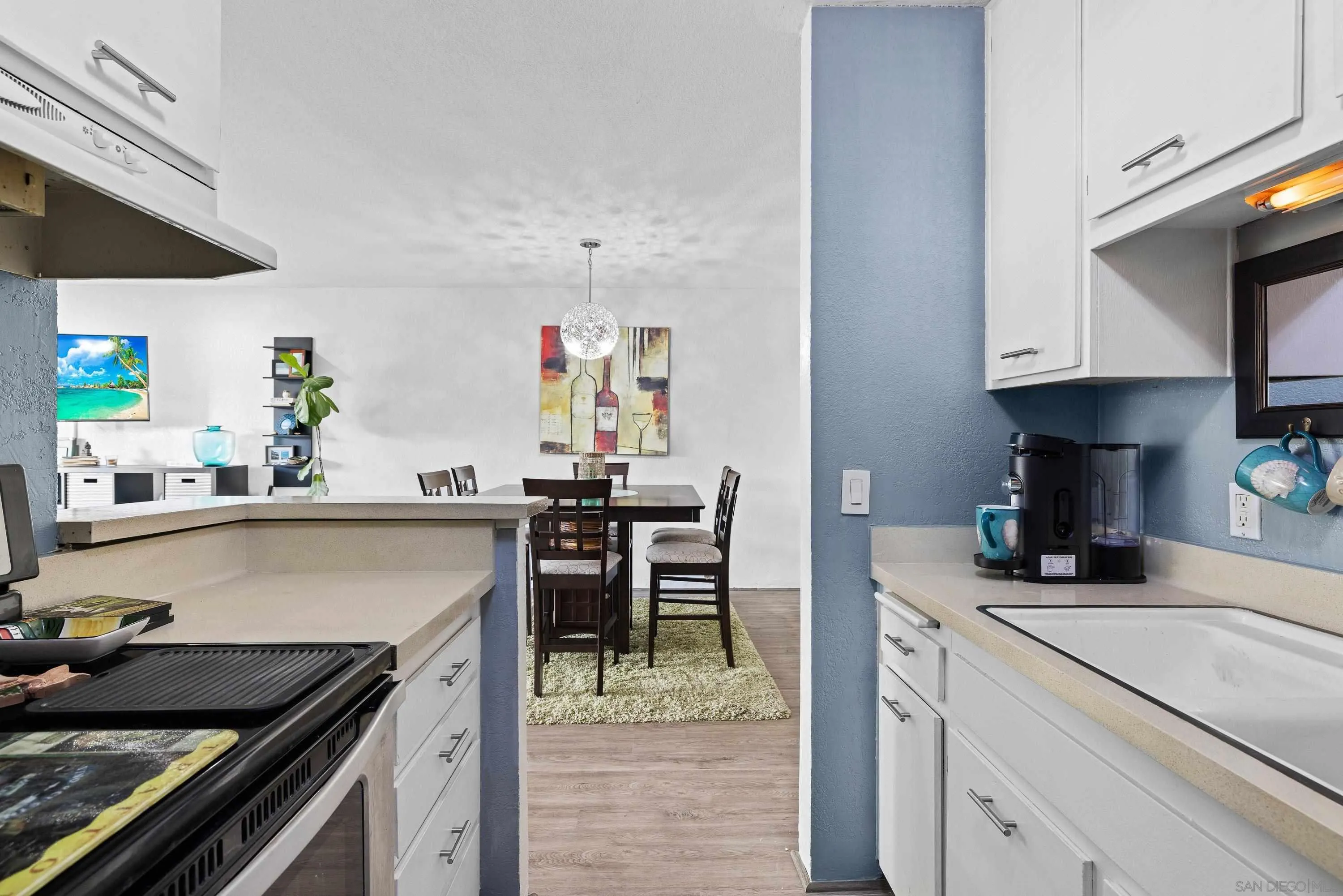 6406 Friars Road, Unit 338 San Diego, CA 92108 - Photo 9 of 36 a kitchen with kitchen island a sink stove and cabinets