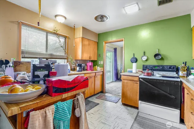 a kitchen that has a lot of cabinets a stove and a wooden floors