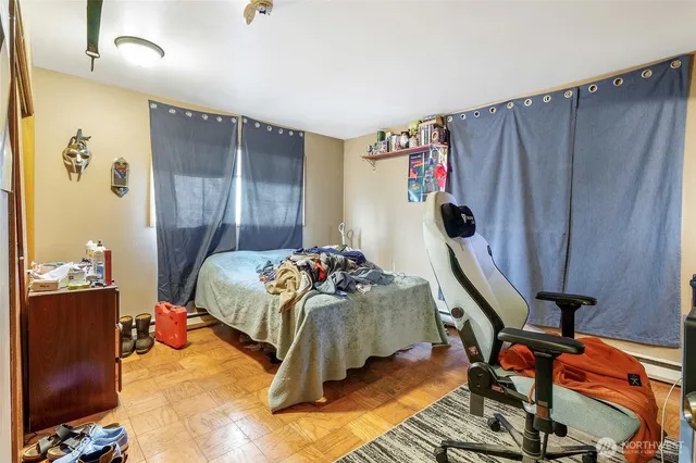 a bedroom with a bed and wooden floor