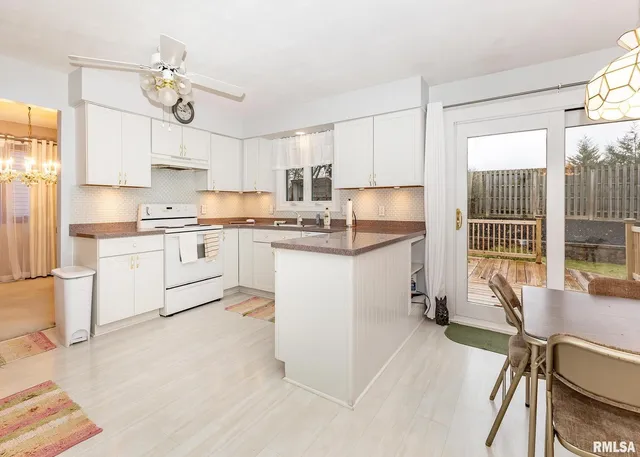 a kitchen with a sink a cabinets and chairs
