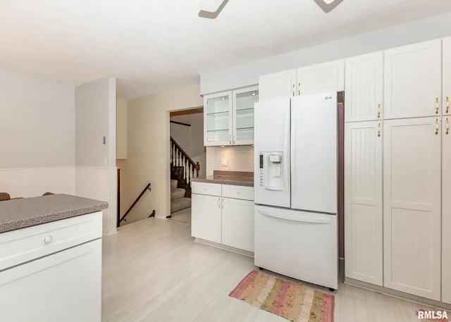 a kitchen with a refrigerator and a stove top oven