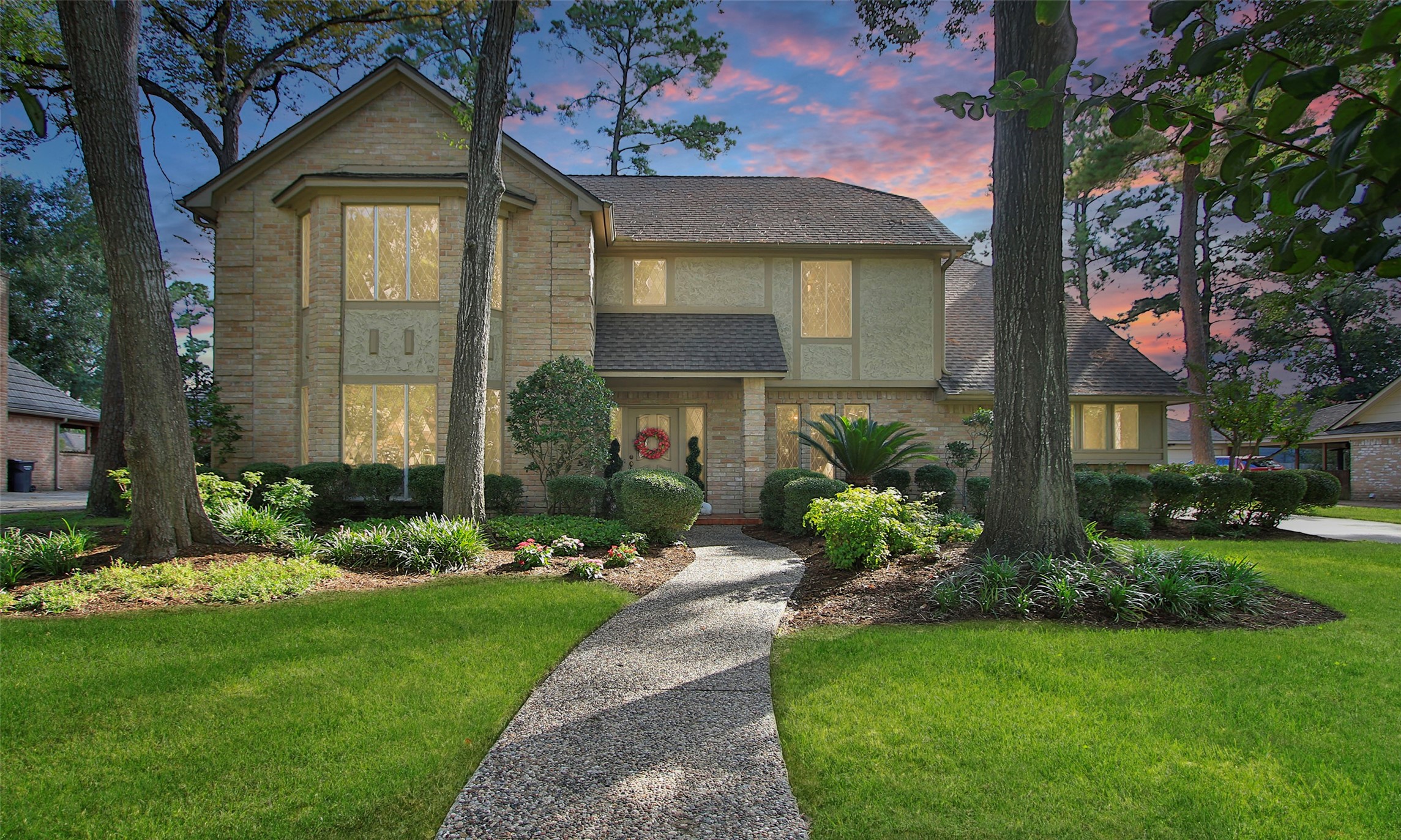 a front view of a house with a yard and potted plants